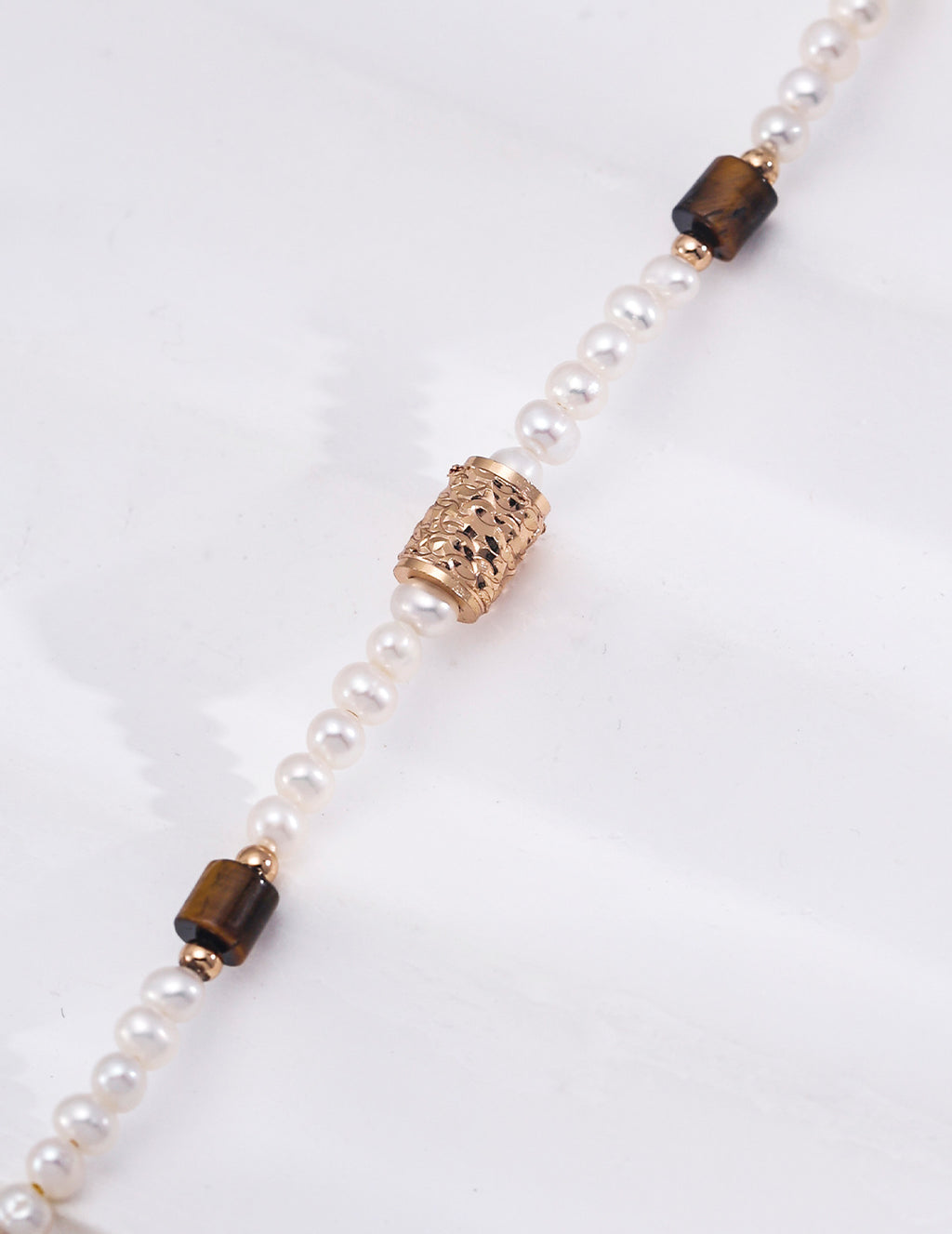 Natural pearl and tiger's eye bracelet close-up — ornate filigree engraved gold barrel bead with cut-work detail, rectangular tiger's eye gemstone beads, freshwater pearls, 18K gold plated S925 silver, BUCKLE Collective