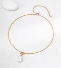 Baroque freshwater pearl pendant necklace laid flat, showing its gold-tone twisted rope chain, lobster clasp and extender