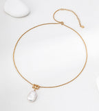 Baroque freshwater pearl pendant necklace laid flat, showing its gold-tone twisted rope chain, lobster clasp and extender