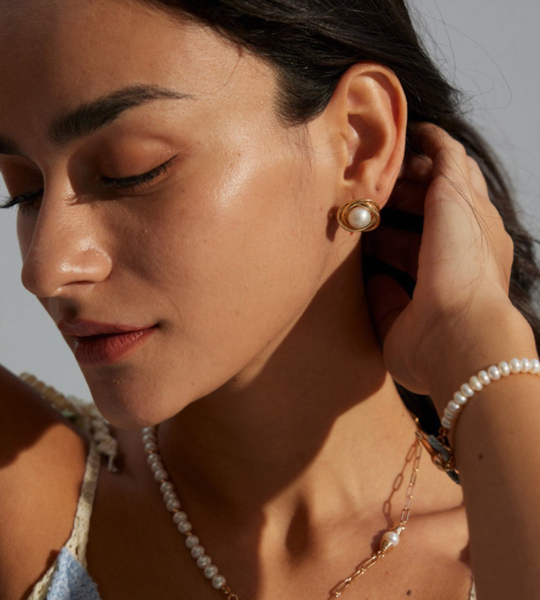 A woman wearing Natural Pearl Twist Stud Earrings with Pearl Necklace and Pearl Bracelet, 18K Gold-Plated on S925 Sterling Silver | BUCKLE Collective