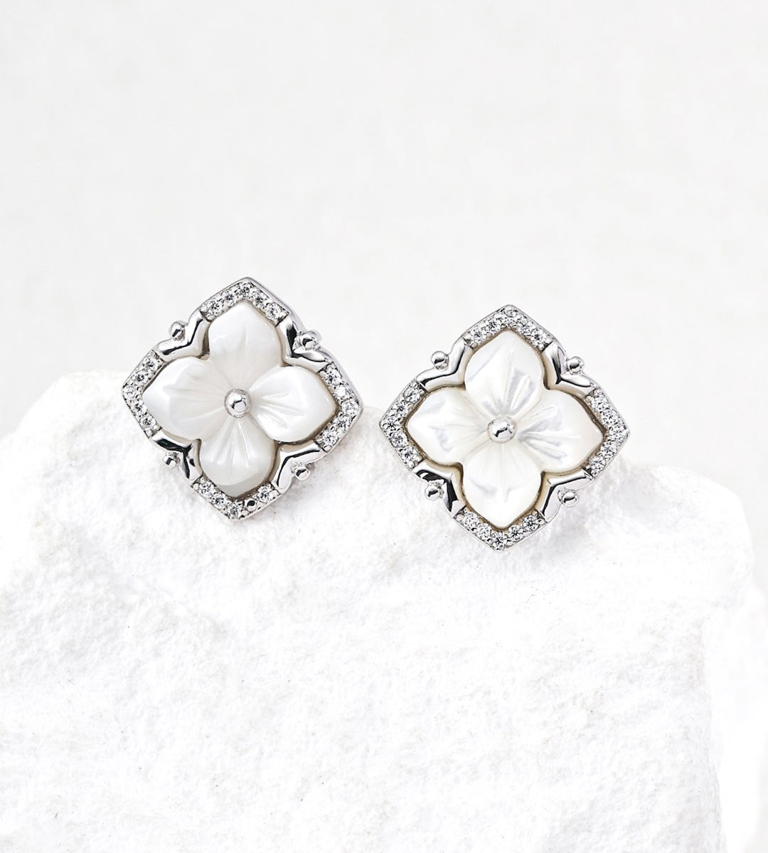 A pair of 18K White Gold Plated S925 Silver floral stud earrings with white mother-of-pearl flower centers and cubic zirconia halos