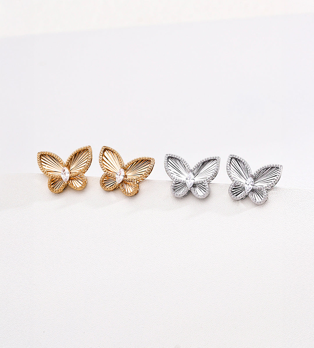 CNC embossed butterfly stud earrings in vintage gold and silver-tone — precision 3D sculpted wings with beaded border and marquise CZ centre, 18K plated S925 sterling silver, BUCKLE Collective