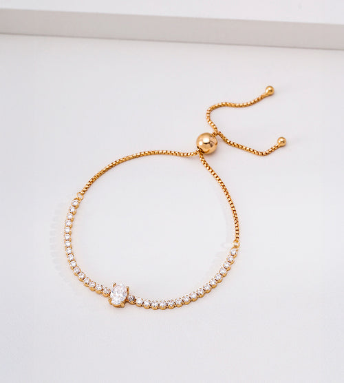 Vintage Gold cubic zirconia tennis bracelet with an oval centre stone, stone-set row and sliding ball adjuster on a white background.