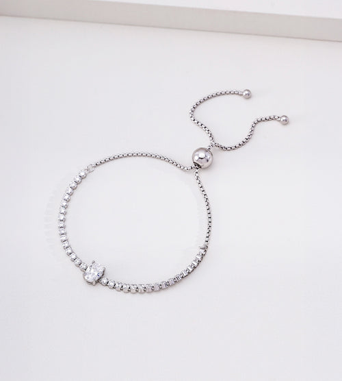Silver-tone adjustable tennis bracelet with an oval cubic zirconia centre stone and twin chain ends with rounded tips.