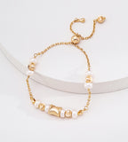 Adjustable freshwater pearl bracelet in 18K vintage gold — wasp-waist engraved charm, natural freshwater pearls, round spacer beads, pull-slide clasp, S925 sterling silver, BUCKLE Collective