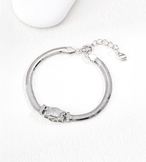 Silver-tone flat snake chain bracelet with a rectangular cubic zirconia centre and small side accents, showing its lobster clasp and extender.
