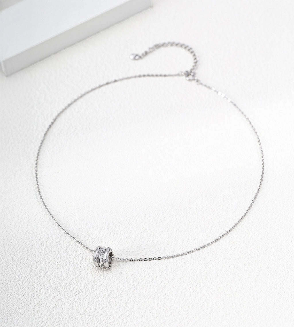 White Gold-finish bamboo-barrel cubic zirconia necklace with a fine chain and extender on a white surface.