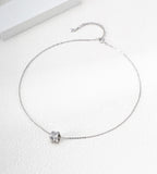 White Gold-finish bamboo-barrel cubic zirconia necklace with a fine chain and extender on a white surface.