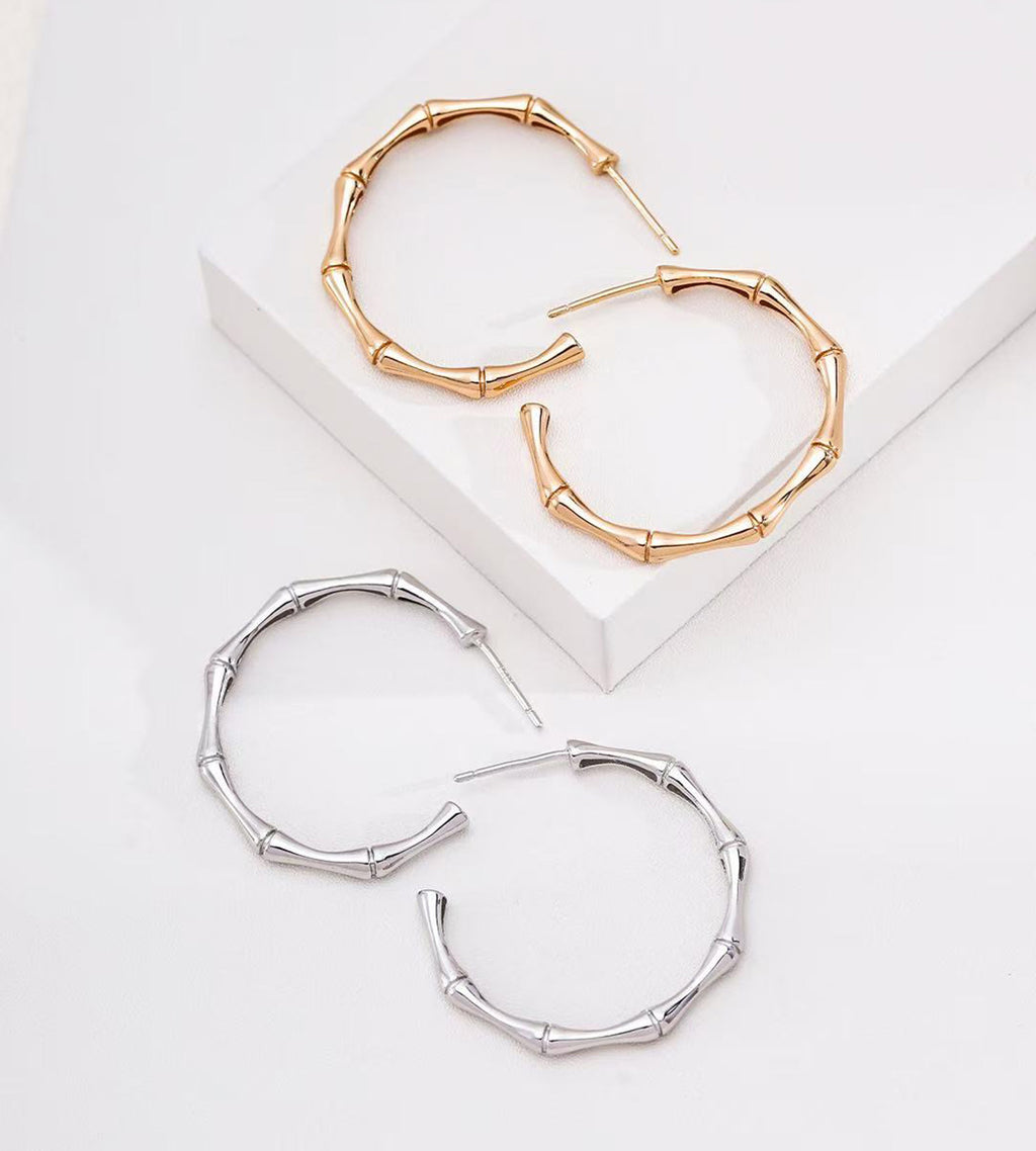 Two hoop earrings with a bamboo-inspired segmented design, shown on a clean white background. One pair is 18K gold-plated, and the other is 18K White gold-plated.