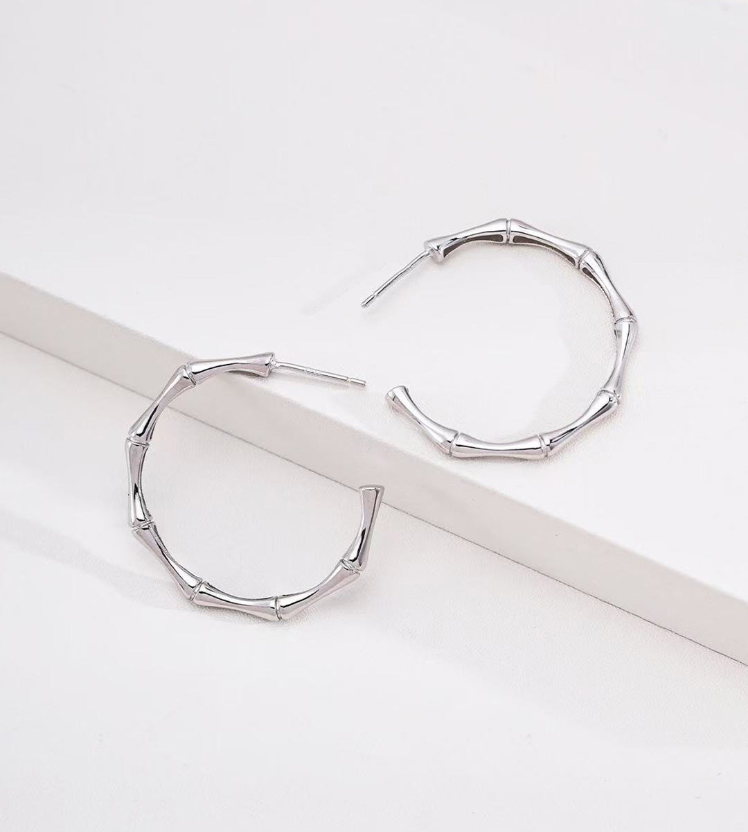 A pair of 18K White-Gold-Plated S925 silver hoop earrings with a bamboo branch link design
