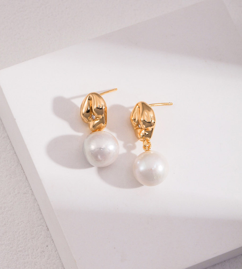 A pair of 18K gold-plated S925 silver drop earrings with a polished gold dumpling-shaped top accented with cirzonia and a dangling baroque white pearl