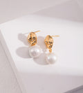 A pair of 18K gold-plated S925 silver drop earrings with a polished gold dumpling-shaped top accented with cirzonia and a dangling baroque white pearl