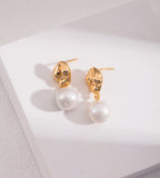 A pair of 18K gold-plated S925 silver drop earrings with a polished gold dumpling-shaped top accented with cirzonia and a dangling baroque white pearl