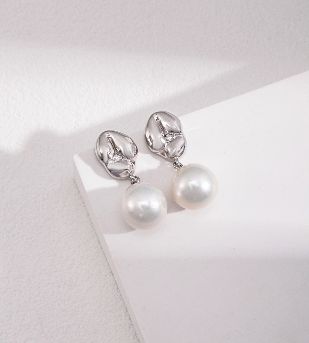 A pair of 18K white-gold-plated S925 silver drop earrings with a polished gold dumpling-shaped top accented with cirzonia and a dangling baroque white pearl