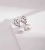 A pair of 18K white-gold-plated S925 silver drop earrings with a polished gold dumpling-shaped top accented with cirzonia and a dangling baroque white pearl