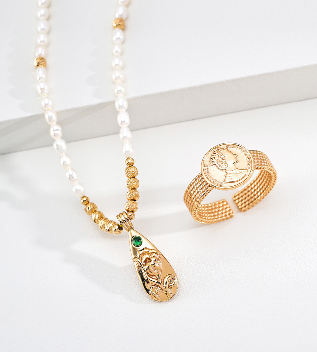 Natural Baroque Seed Pearl Necklace with Engraved Floral Pendant lying with open design Queen Coin Ring, 18K Gold-Plated over S925 Sterling Silver