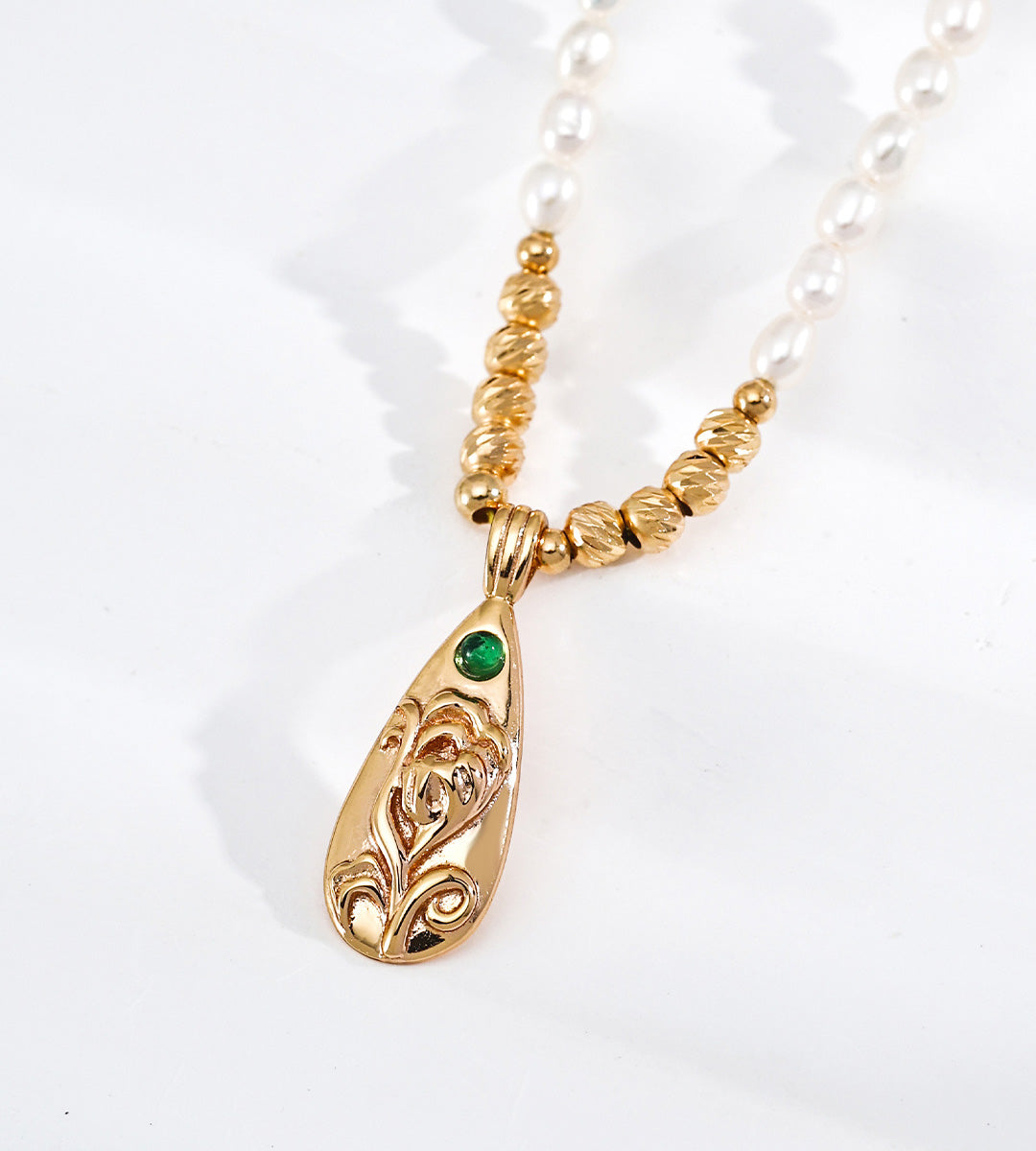Close-up photo on Natural Baroque Seed Pearl Necklace with Engraved Floral Pendant with a Green Zircon, 18K Gold-Plated over S925 Sterling Silver