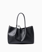 A black woven leather large tote bag with double top handles and a drawstring detail