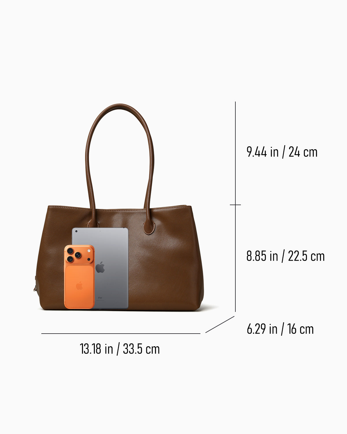Brown leather commuter tote bag shown with overlaid dimensions and phone with tablet for scale
