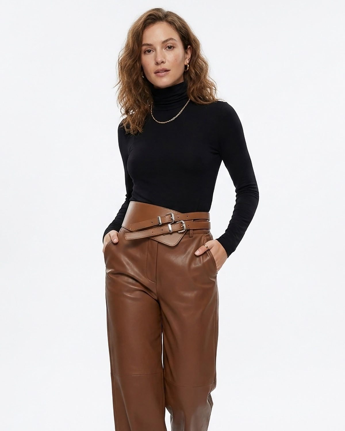 A woman modeling a black long-sleeve turtleneck top and brown leather wide-leg pants with a matching wide double-buckle statement brown belt | BUCKLE Collective
