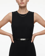A model wearing a sleeveless black dress with a thin black saffiano leather belt with a silver-tone turn-lock buckle