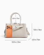 Off-White Commuter Genuine Togo Leather Satchel Bag with Turn-Lock & Detachable Strap, shown with overlaid dimension lines and measurements for width, height, and depth, alongside a phone used for scale | BUCKLE Collective