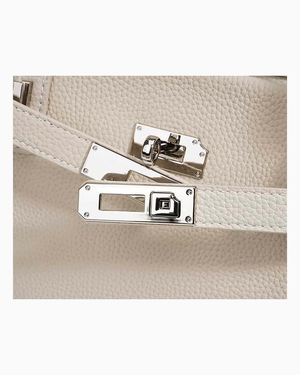 Close-up of an off-white pebbled Togo leather handbag with silver-toned turn-lock closure