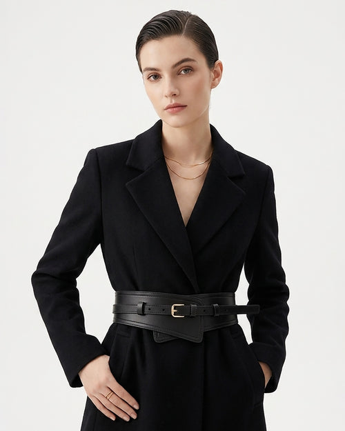 A woman modeling a black tailored coat with a 2-in-1 wide black statement leather belt featuring a gold buckle | BUCKLE Collective