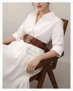 A woman in an elegant white dress wearing a 2‑in‑1 transformable leather corset belt with a gold buckle. The belt transforms from a statement, wide design into a classic design, Caramel Color