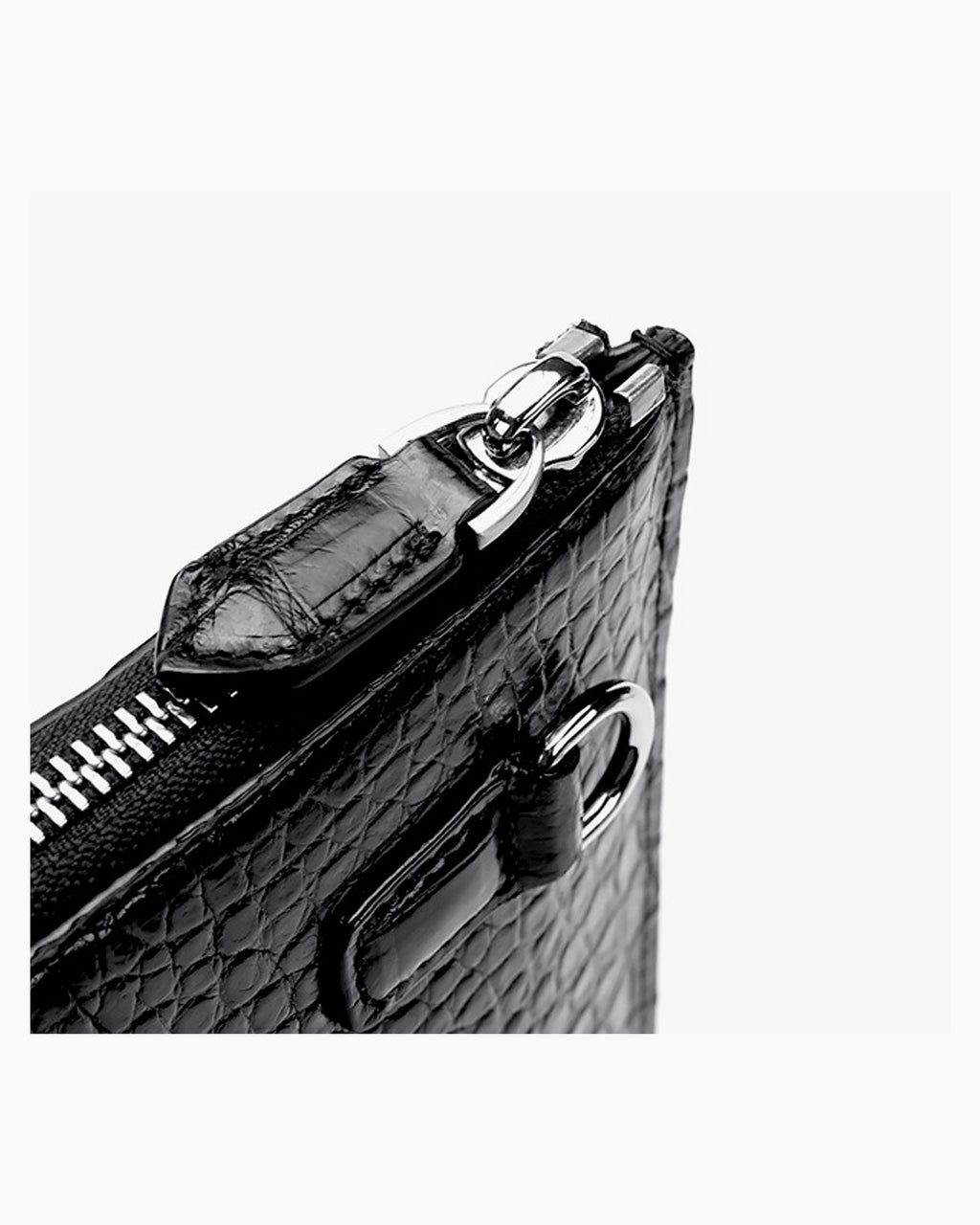 Close-up of a black genuine crocodile leather zippered clutch with silver-tone hardware | BUCKLE Collective
