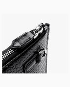 Close-up of a black genuine crocodile leather zippered clutch with silver-tone hardware | BUCKLE Collective