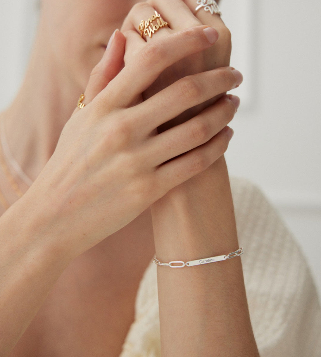 Model wearing "Your Name" Custom Letter Bracelet on the wrist with the name Caroline on it, 925 Sterling Silver, 18K Gold-plated