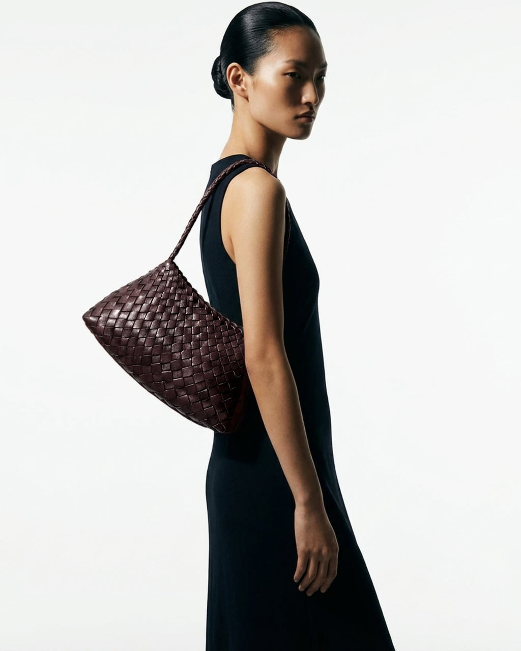 Woman in a stylish black dress with Woven Shoulder Bag made of Handwoven Buffalo Leather in Brown Color