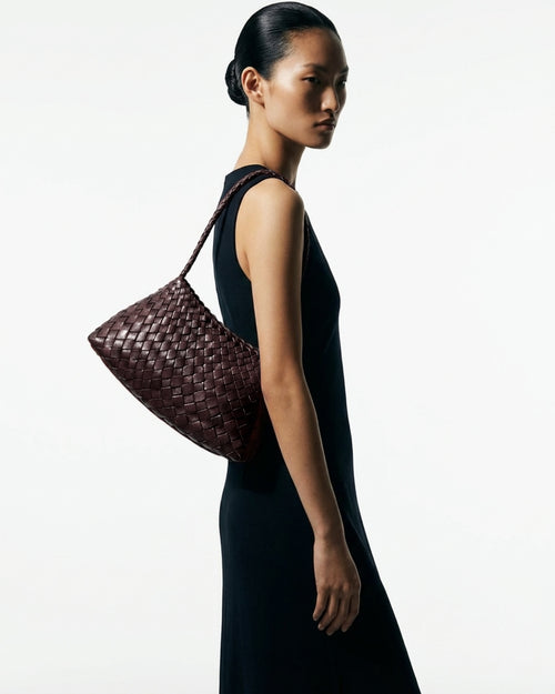 Woman in a stylish black dress with Woven Shoulder Bag made of Handwoven Buffalo Leather in Brown Color