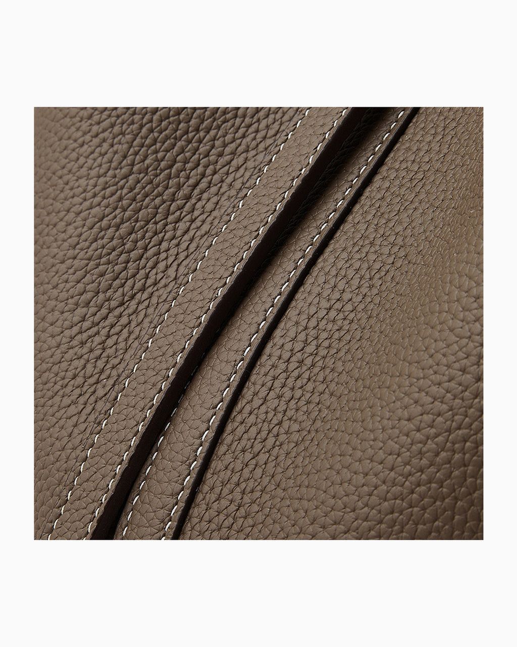 Close-up of a brown Togo leather surface with diagonal stitching details.