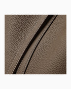 Close-up of a brown Togo leather surface with diagonal stitching details.