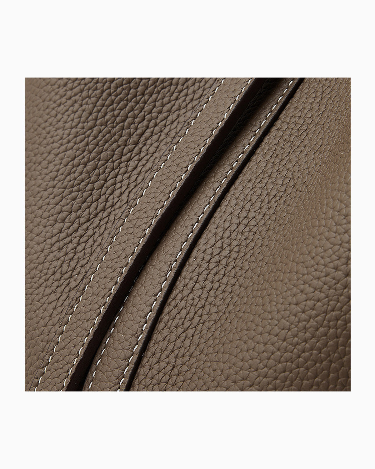 Close-up of a brown Togo leather surface with diagonal stitching details.