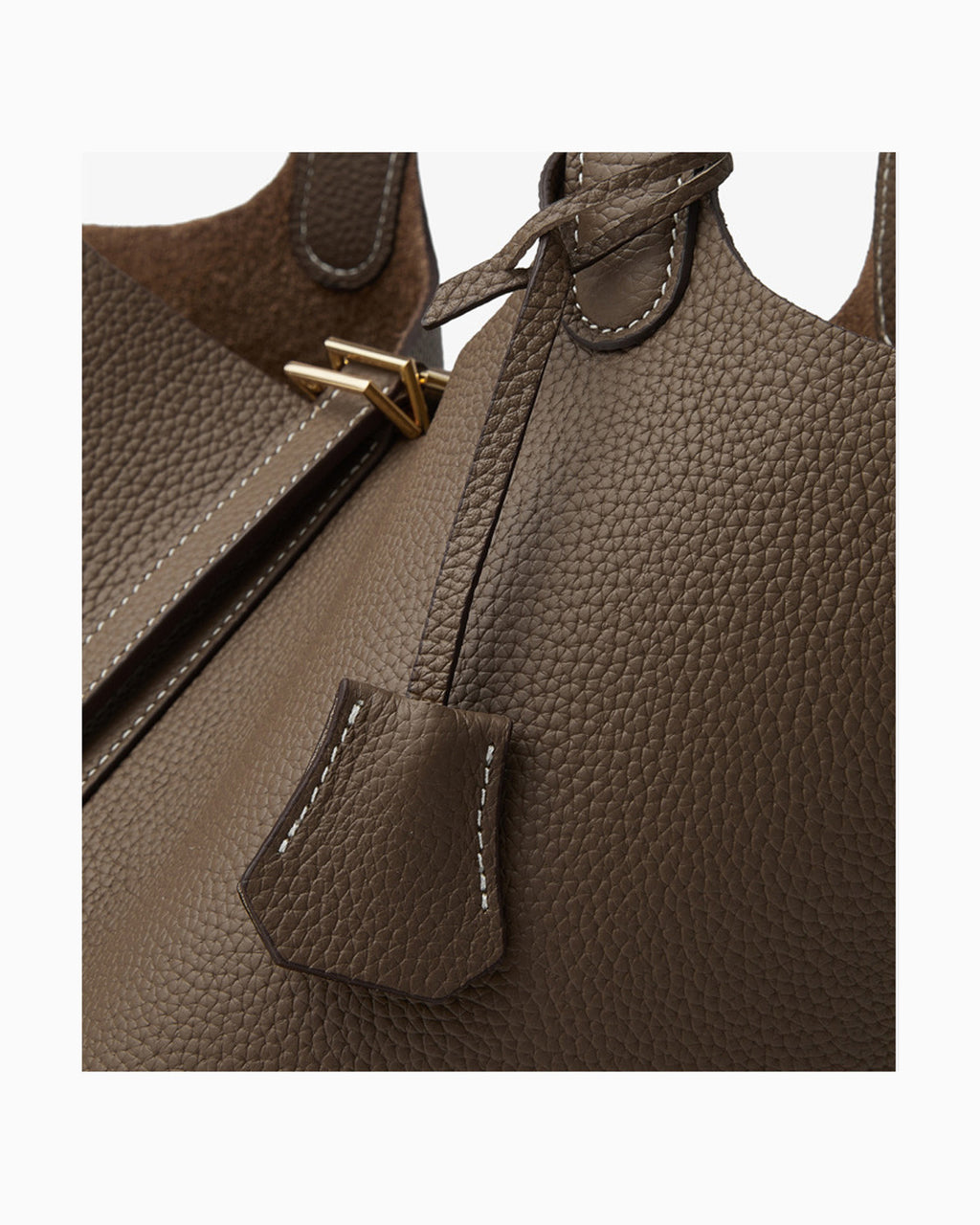 Close-up of a brown Togo leather handbag showing the strap attachment, gold-tone hardware, and white contrast stitching
