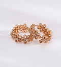 Floral hollow-carved huggie hoop earrings in 18K vintage gold plating — continuous CZ flower band, openwork floral silhouette, S925 sterling silver, BUCKLE Collective