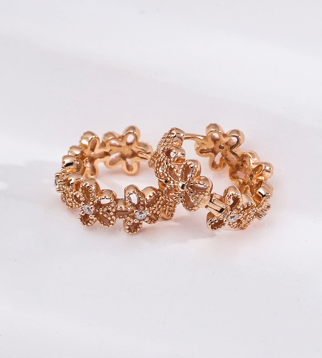 Floral hollow-carved huggie hoop earrings in 18K vintage gold plating — continuous CZ flower band, openwork floral silhouette, S925 sterling silver, BUCKLE Collective