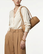 Woman wearing a stylish smart-casual outfit with a Leather Baguette Handbag in Apricot Color