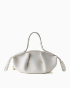 A white leather handbag with a unique sculptural, gathered shape, double top handles, and knotted leather strap ends by BUCKLE Collective