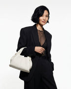 A woman in a fashion-forward evening date black outfit with Off-White Genuine Leather Cloud-shaped Satchel Handbag 