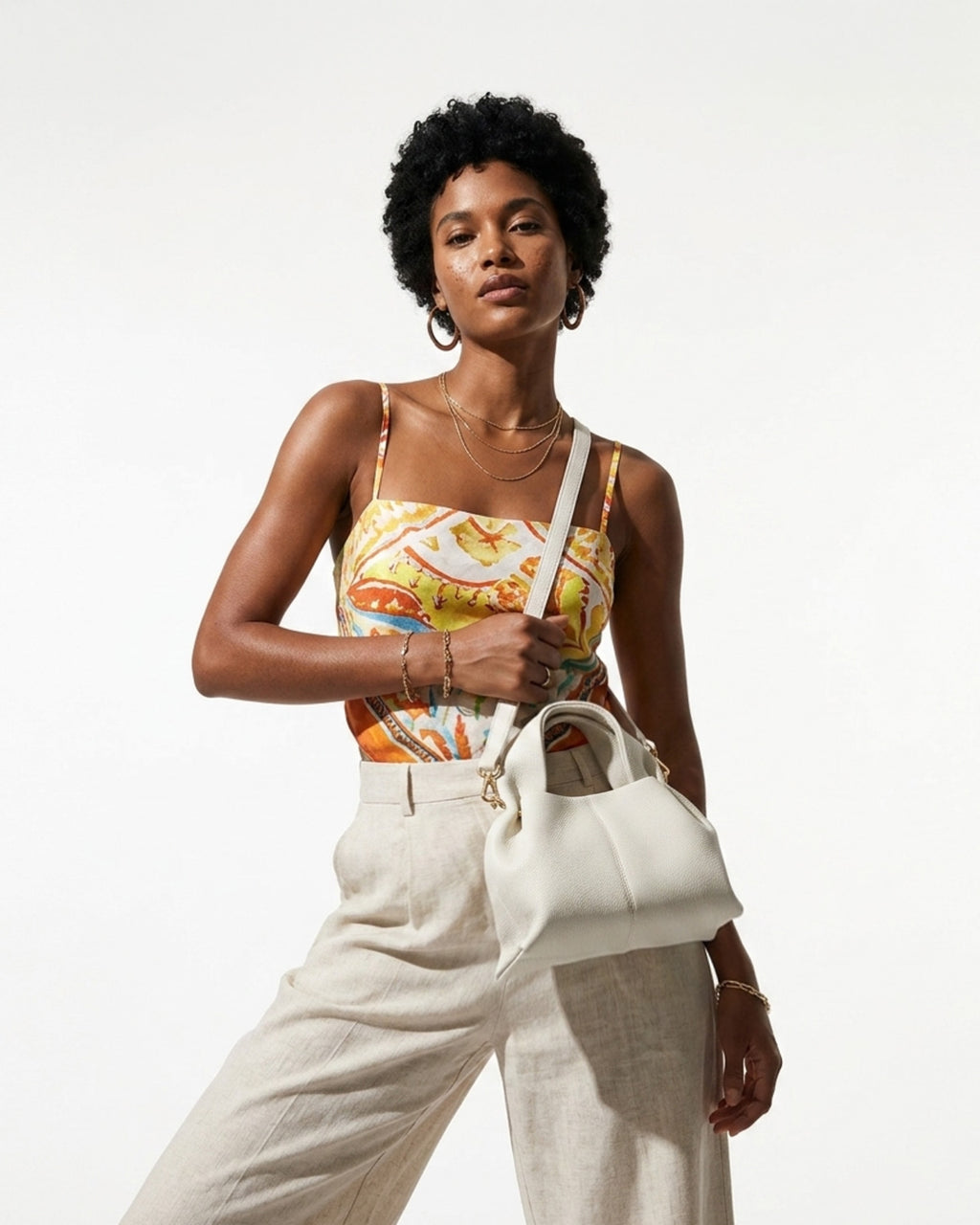 A woman in a stylish, vibrant summer outfit carries a White Genuine Leather Cloud-shaped Satchel Handbag with Detachable Strap