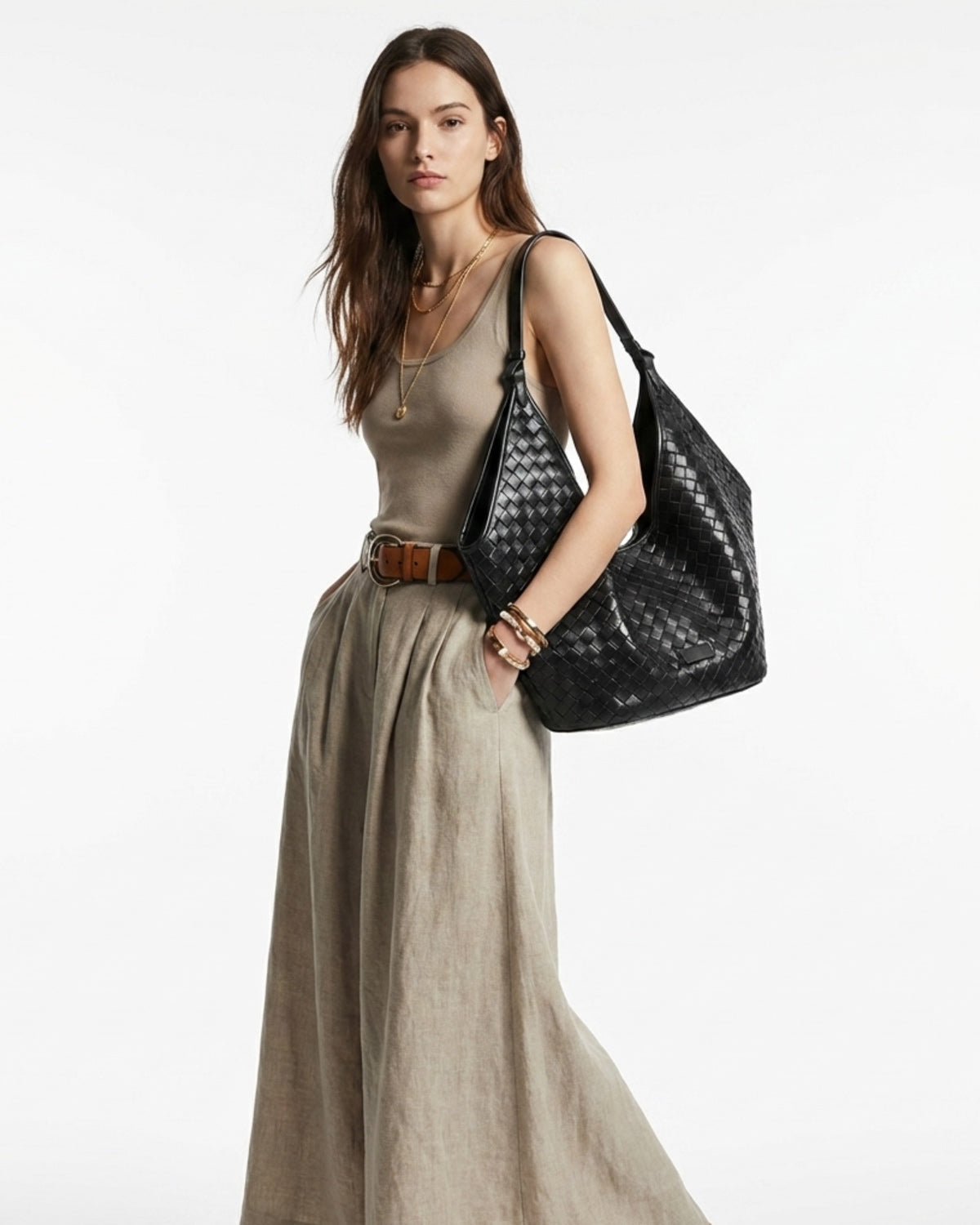 Elegant woman in a stylish casual outfit with a black woven genuine leather hobo shoulder tote bag