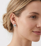 A close-up of a woman's ear and side profile wearing Glitter Textured Pillow Huggie Earrings | 18K Gold Plated S925 Silver | BUCKLE Collective