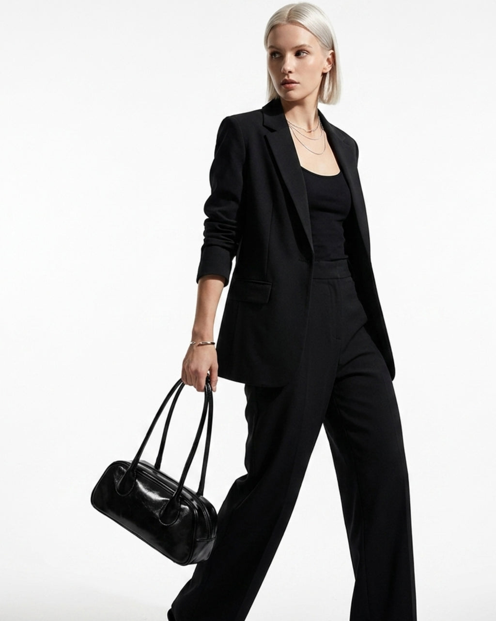 Elegant Woman in a stylish black outfit wearing a chic black genuine leather shoulder baguette bag