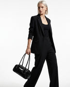 Elegant Woman in a stylish black outfit wearing a chic black genuine leather shoulder baguette bag