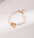 Good Luck baroque freshwater pearl bracelet in vintage gold — engraved "Good Luck" square tag and heart charm, 18K gold plated S925 sterling silver, adjustable lobster clasp, BUCKLE Collective