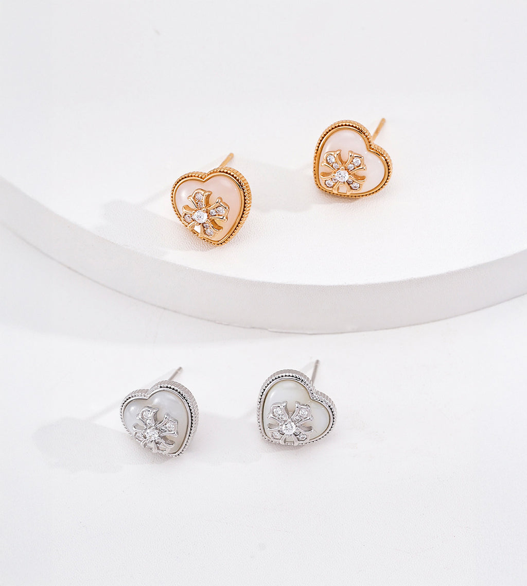 Vintage Gold heart studs on a raised white display with silver-tone studs below, showing mother-of-pearl hearts and sparkling flower details.